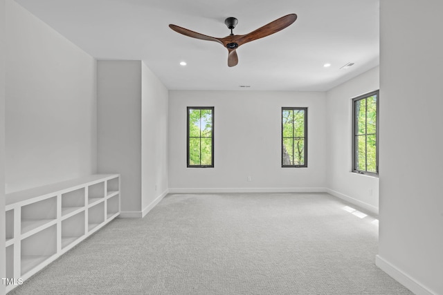 empty room with a ceiling fan, baseboards, a healthy amount of sunlight, and carpet