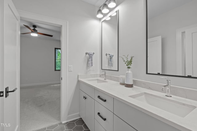 full bathroom featuring a sink, baseboards, ceiling fan, and double vanity