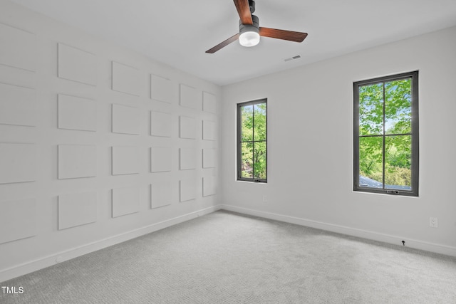 empty room featuring baseboards, ceiling fan, carpet floors, and visible vents
