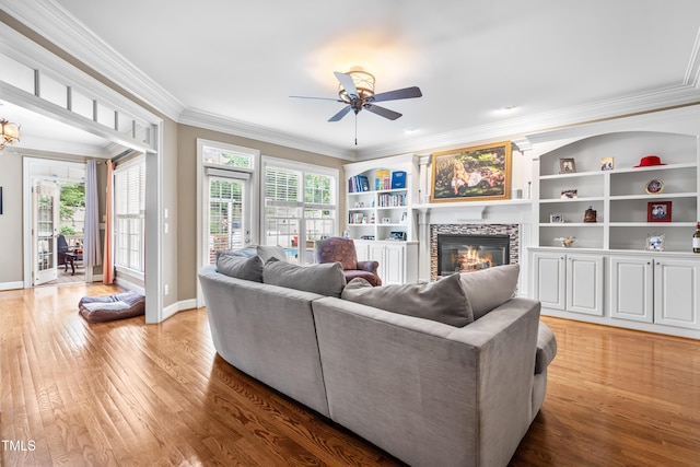 3821 Falls River Ave, Raleigh, NC 27614 - living area featuring a glass covered fireplace, a ceiling fan, plenty of natural light, light wood-type flooring, and ornamental molding