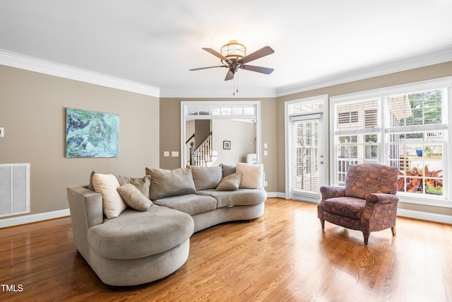 3821 Falls River Ave, Raleigh, NC 27614 - living area featuring crown molding, baseboards, a ceiling fan, stairway, and plenty of natural light