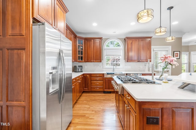 3821 Falls River Ave, Raleigh, NC 27614 - kitchen featuring appliances with stainless steel finishes, light countertops, light wood-style flooring, crown molding, and a sink