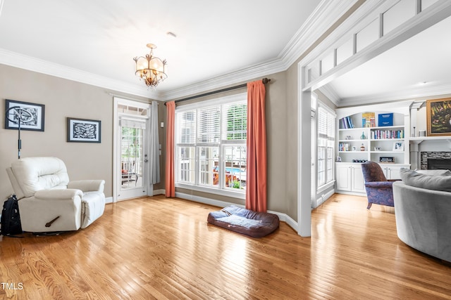 3821 Falls River Ave, Raleigh, NC 27614 - living area featuring ornamental molding, a chandelier, light wood-type flooring, a fireplace, and baseboards