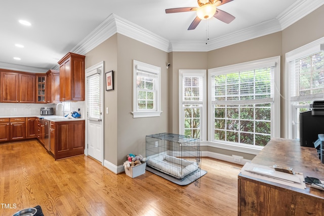 3821 Falls River Ave, Raleigh, NC 27614 - kitchen with a ceiling fan, light wood finished floors, brown cabinets, light countertops, and crown molding