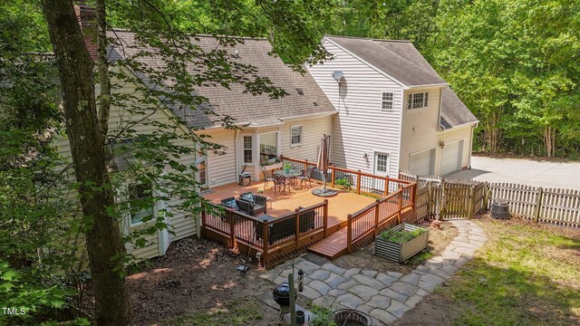 63 Tally Ho Dr, Selma, NC 27576 - back of property with fence, driveway, a shingled roof, a wooden deck, and an attached garage