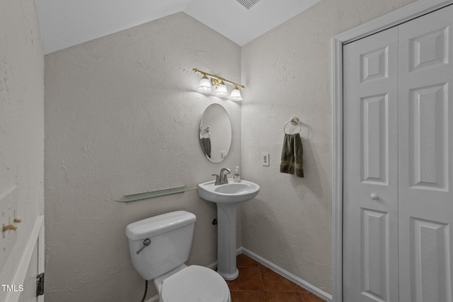 63 Tally Ho Dr, Selma, NC 27576 - bathroom featuring tile patterned floors, toilet, a closet, and vaulted ceiling
