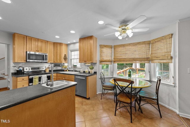 63 Tally Ho Dr, Selma, NC 27576 - kitchen with appliances with stainless steel finishes, a sink, dark countertops, tasteful backsplash, and ceiling fan