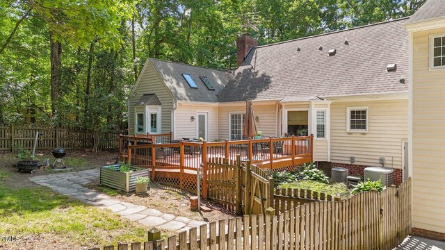 63 Tally Ho Dr, Selma, NC 27576 - rear view of property with a deck, a chimney, a fenced backyard, roof with shingles, and central air condition unit