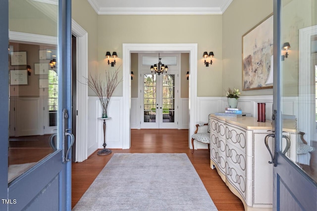 417 Westbury Dr, Chapel Hill, NC 27516 - foyer entrance featuring french doors, a wainscoted wall, an inviting chandelier, and dark wood finished floors