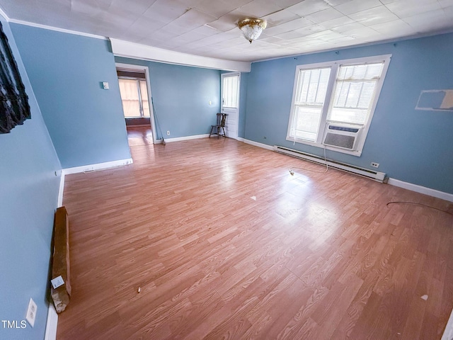 spare room featuring a baseboard radiator, baseboards, cooling unit, and wood finished floors