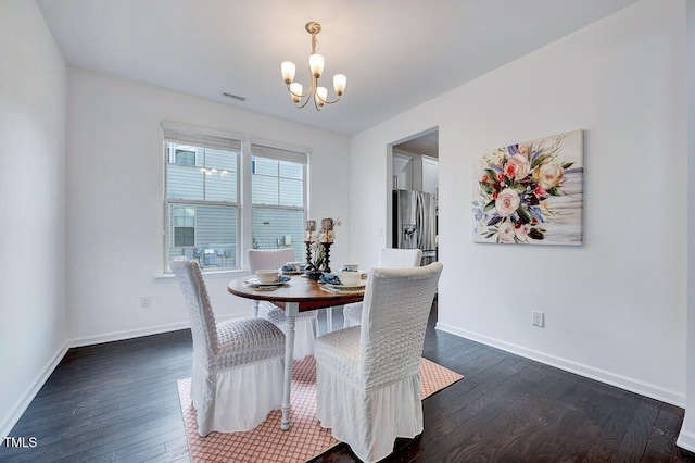 dining space featuring a chandelier, dark wood-style flooring, baseboards, and visible vents