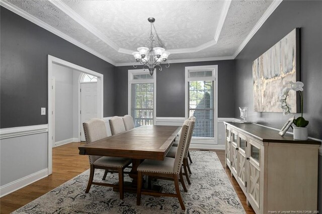 6826 Surrey Rd, Fayetteville, NC 28306 - dining room with a textured ceiling, dark wood-style flooring, a tray ceiling, and a chandelier