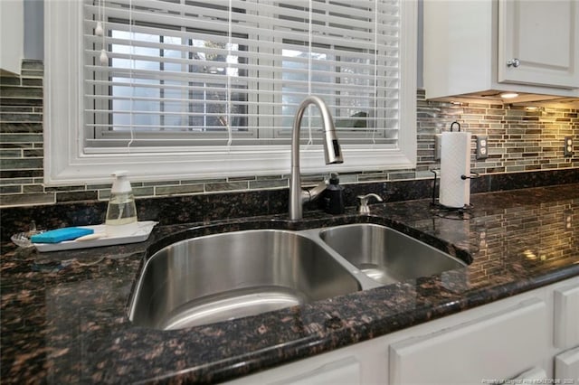 6826 Surrey Rd, Fayetteville, NC 28306 - details featuring white cabinetry, tasteful backsplash, dark stone countertops, and a sink
