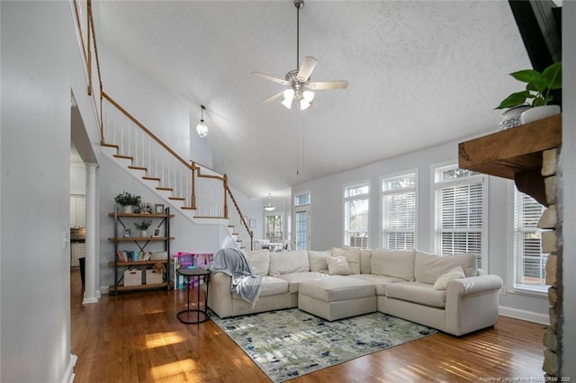 6826 Surrey Rd, Fayetteville, NC 28306 - living room with a ceiling fan, high vaulted ceiling, stairs, and wood finished floors