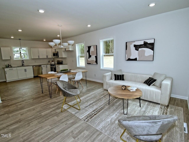 living room with recessed lighting, baseboards, and wood finished floors