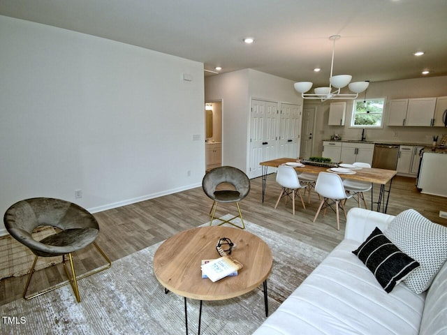 living area featuring light wood-style floors, baseboards, and recessed lighting