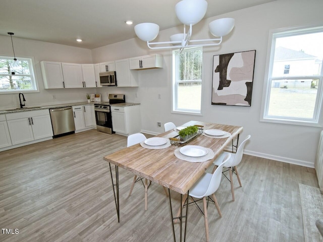 dining area featuring light wood-style flooring, baseboards, and recessed lighting