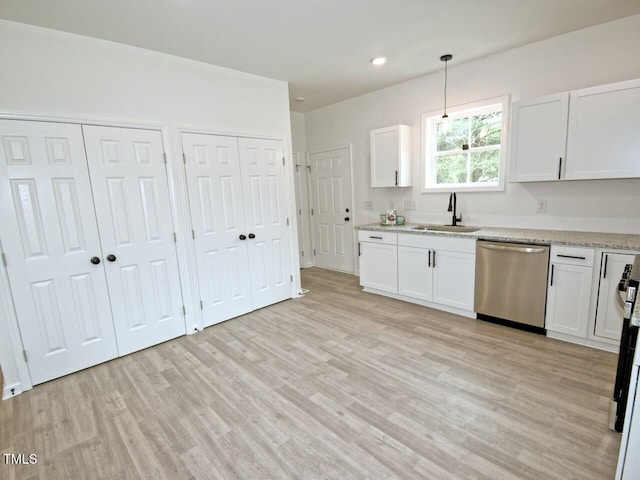 kitchen with light wood finished floors, stainless steel dishwasher, and a sink