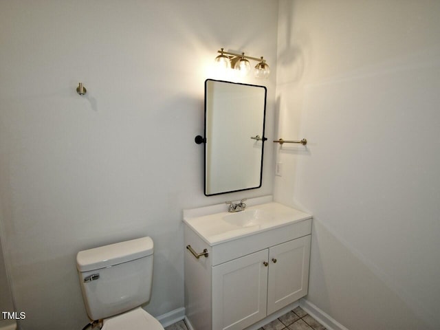 bathroom with toilet, baseboards, and vanity