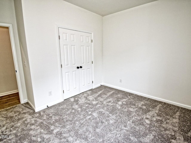 unfurnished bedroom featuring a closet, baseboards, and carpet