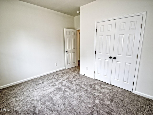 unfurnished bedroom featuring carpet floors, baseboards, and a closet