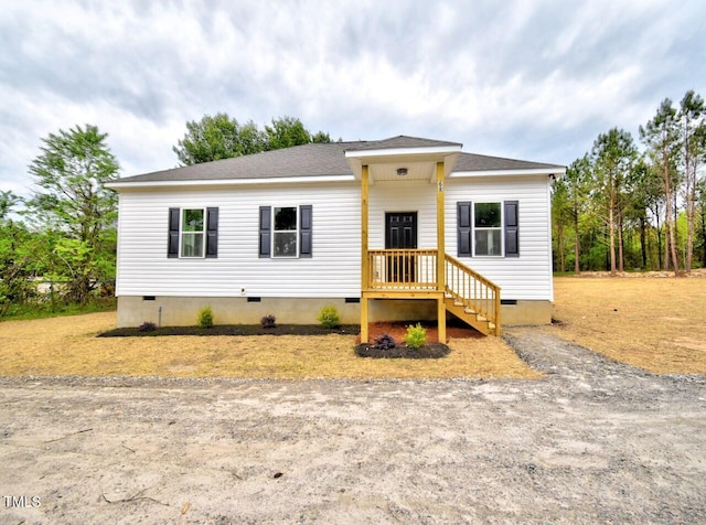 view of front of home with crawl space and roof with shingles