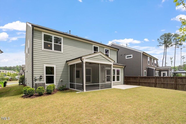 rear view of property featuring a yard, fence, and a sunroom