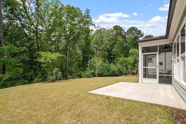 view of yard featuring a ceiling fan, a sunroom, and a patio area