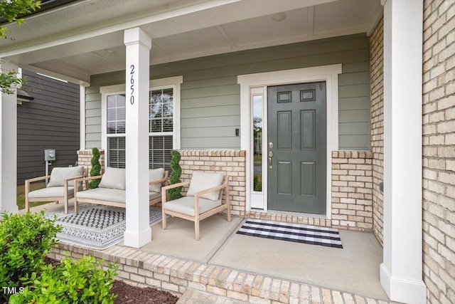 property entrance featuring covered porch and brick siding