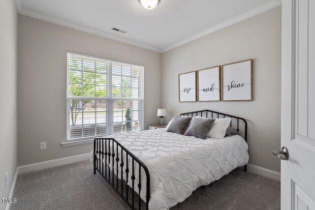 bedroom with crown molding, baseboards, carpet flooring, and visible vents