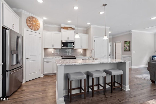kitchen with a sink, dark wood finished floors, stainless steel appliances, white cabinetry, and ornamental molding