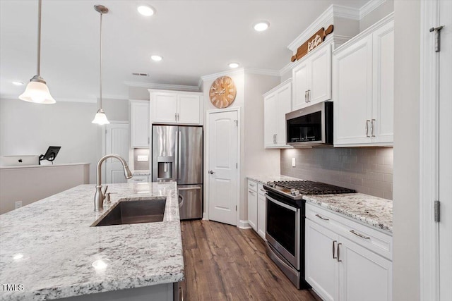 kitchen featuring ornamental molding, white cabinetry, tasteful backsplash, a sink, and stainless steel appliances