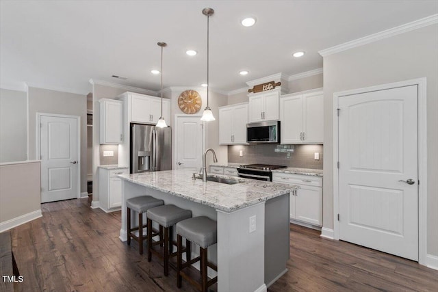 kitchen with a sink, decorative backsplash, appliances with stainless steel finishes, and white cabinets