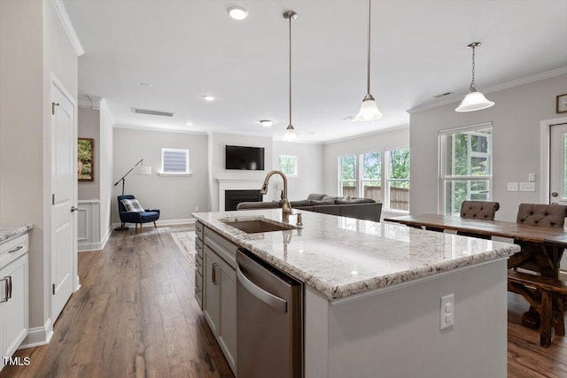 kitchen with visible vents, dishwasher, a sink, open floor plan, and ornamental molding