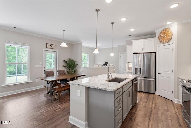 kitchen with visible vents, an island with sink, dark wood-type flooring, a sink, and stainless steel appliances