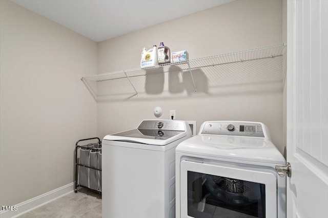 laundry room featuring separate washer and dryer, laundry area, and baseboards