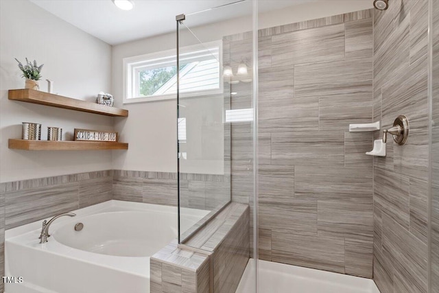 bathroom featuring a bath and a stall shower