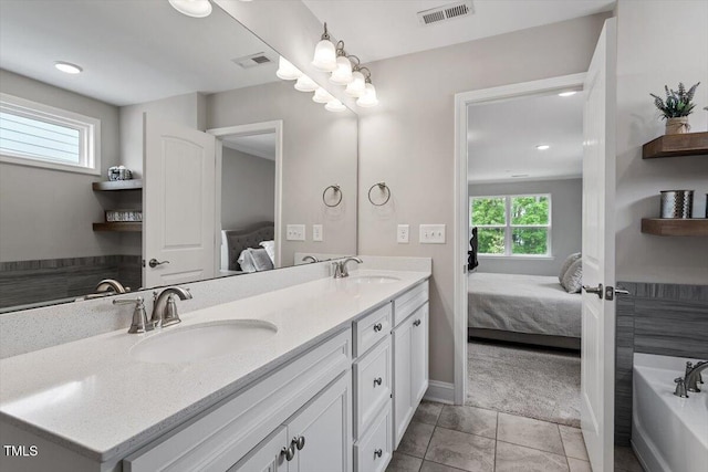 bathroom with ensuite bathroom, a sink, and visible vents
