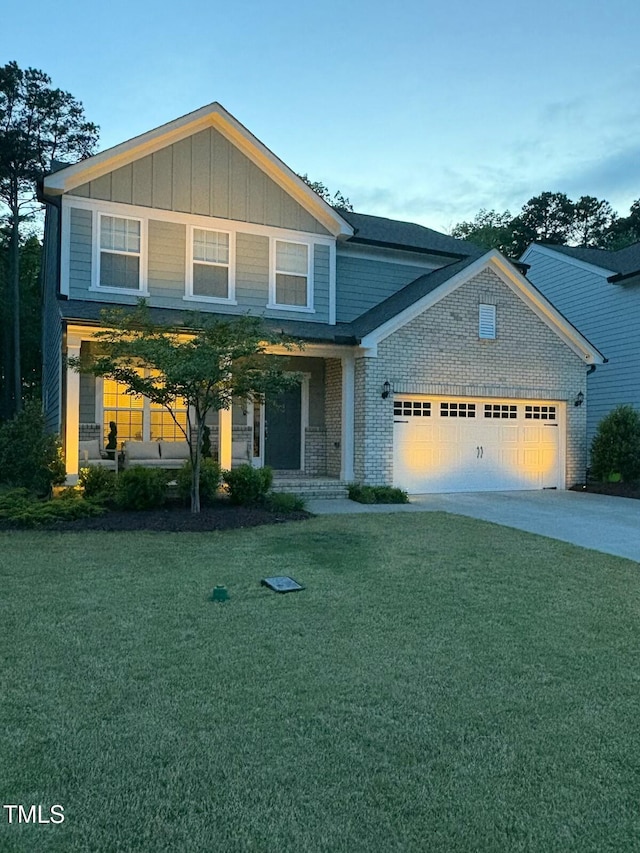 view of front of property with a garage, a front yard, brick siding, a porch, and driveway