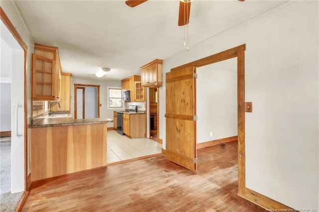 5213 Palmetto Ln, Fayetteville, NC 28304 - kitchen with glass insert cabinets, electric range oven, a sink, ceiling fan, and light wood-style flooring