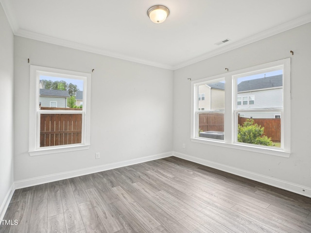 unfurnished room with baseboards, wood finished floors, and ornamental molding