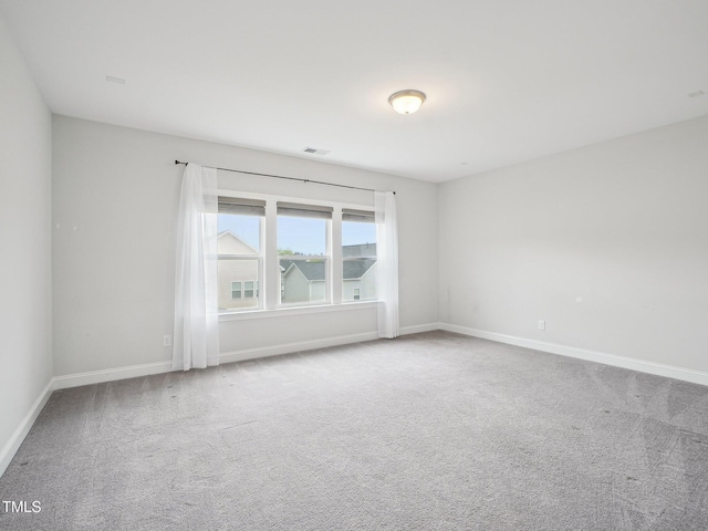 carpeted empty room with visible vents and baseboards