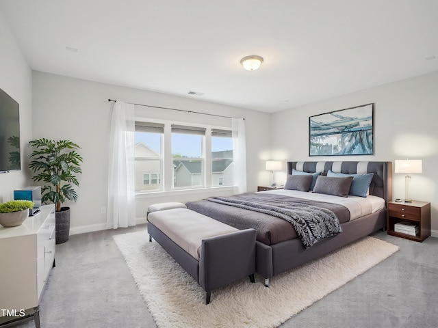 bedroom with light colored carpet and baseboards