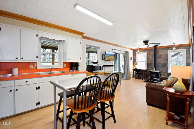 1471 Bamboo Rd, Boone, NC 28607 - kitchen featuring a sink, crown molding, stainless steel microwave, a wood stove, and light wood-style floors