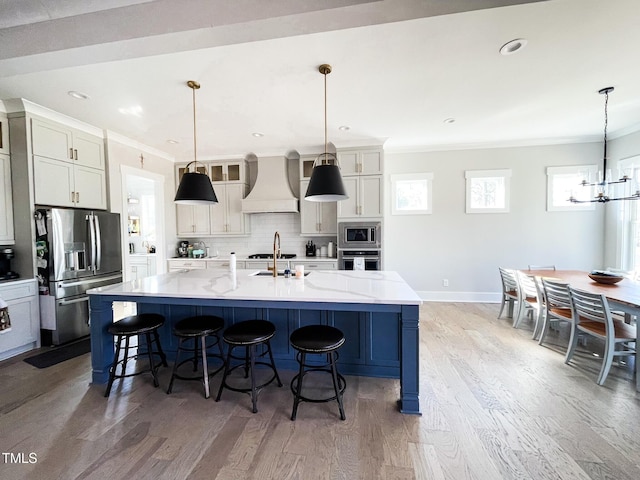 14 Duck Bill Trl, Pittsboro, NC 27312 - kitchen featuring stainless steel appliances, custom range hood, a chandelier, decorative backsplash, and light wood-type flooring