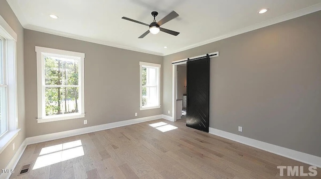 14 Duck Bill Trl, Pittsboro, NC 27312 - unfurnished bedroom with a barn door, multiple windows, light wood finished floors, baseboards, and ornamental molding