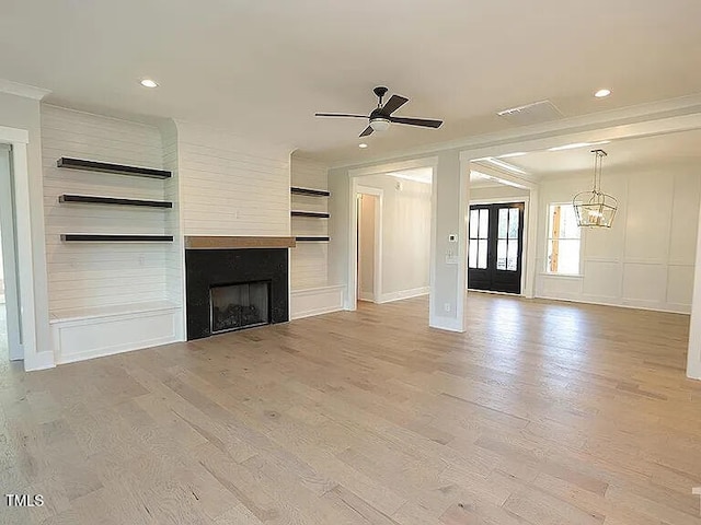 14 Duck Bill Trl, Pittsboro, NC 27312 - unfurnished living room featuring ceiling fan, ornamental molding, a large fireplace, light wood-style flooring, and a chandelier