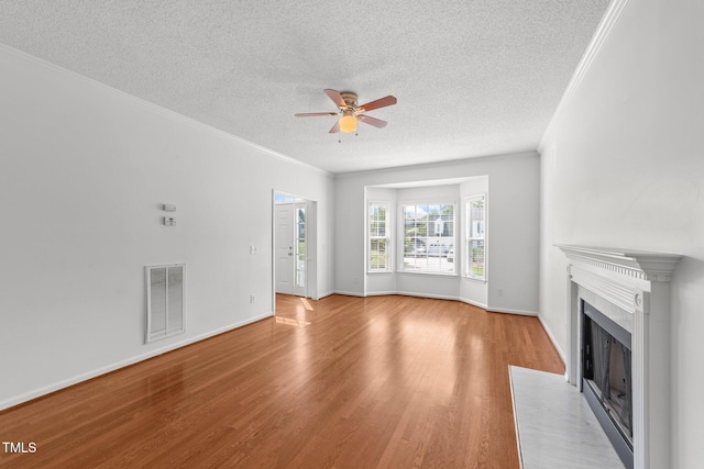 1308 Aspen Falls Ct, Willow Springs, NC 27592 - unfurnished living room with a ceiling fan, a textured ceiling, visible vents, a fireplace with flush hearth, and light wood-style floors