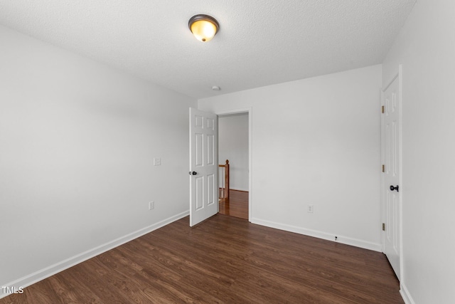 1308 Aspen Falls Ct, Willow Springs, NC 27592 - spare room with baseboards, dark wood finished floors, and a textured ceiling