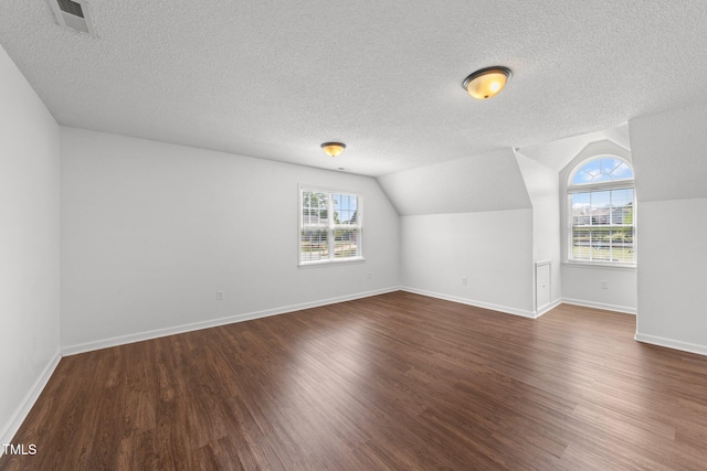 1308 Aspen Falls Ct, Willow Springs, NC 27592 - additional living space with lofted ceiling, dark wood finished floors, a textured ceiling, and visible vents